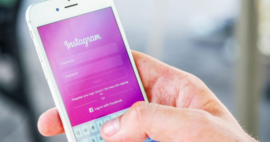 Persona usando la app de Instagram en un smartphone, representando la dependencia digital en negocios.